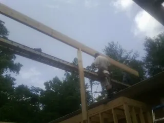 Carpenter setting a ridge beam over a new addition frame — Ice Dam Removal by Roofing Brothers in Westport