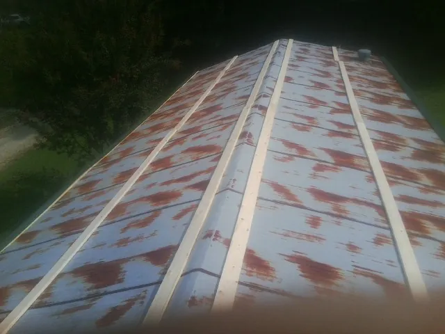 Rusted metal roof panels with new wood purlins before replacement — Storm Damage Roof Repair in Westport by Roofing Brothers